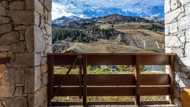 A stone wall with a wooden bench overlooking a mountainous landscape with a clear sky. - 130m from ski slopes, 8th floor, view mountain, balcony, ski locker, 23m², Méribel-Mottaret (Méribel - Les Allues)