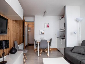 A modern living space with a dining area, kitchen, and seating area.