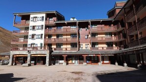 Un hôtel à plusieurs étages doté de balcons, d’un restaurant et d’un café.
