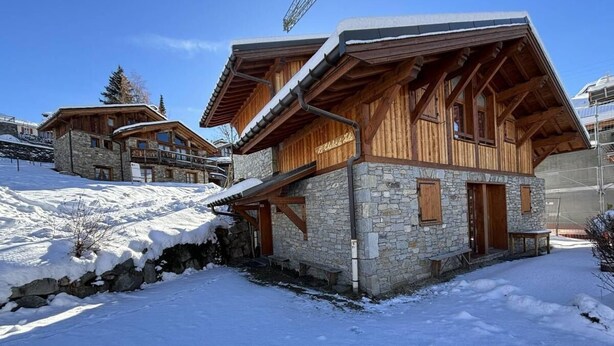 A chalet-style building with stone walls and wooden beams, featuring a balcony and a stone staircase leading to the entrance. - Chalet, 160m from resort center, view mountain, terrace, parking, tv, ski locker, 65m² (Saint-Martin-de-Belleville)