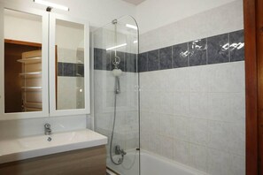 A modern bathroom with a glass-enclosed shower, a white sink, and a mirror above it. - Resort center, 3rd floor, swimming pool, sauna, balcony, tv, ski locker, 35m², Les Orres (Les Orres)