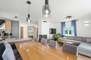 Un espace de vie moderne comprenant un coin repas, une cuisine et un coin salon.