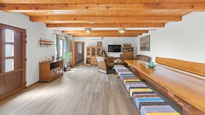 A wooden interior with a long bench, a television, and a dining table. - Villa Marko by Aneo Travel (Ledenice)