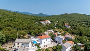 A residential area with houses, a swimming pool, and a mountainous backdrop. - Villa Marko by Aneo Travel (Ledenice)