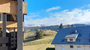 Une vue d’une maison avec un toit en pente et une cour clôturée.