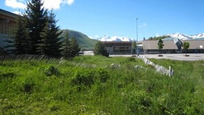 A building with a modern design, surrounded by a grassy area and a mountain in the background.