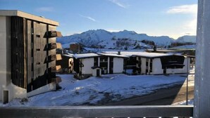 A modern building with a snow-covered landscape and mountains in the background. - 50m from ski slopes, 2nd floor, balcony, tv, 66m², Alpe d'Huez (L'Alpe d'Huez)