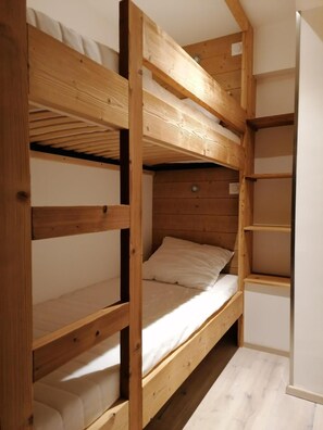 A bunk bed with a wooden frame and white bedding. - 100m from resort center, 1st floor, balcony, tv, 41m², Alpe d'Huez (L'Alpe d'Huez)