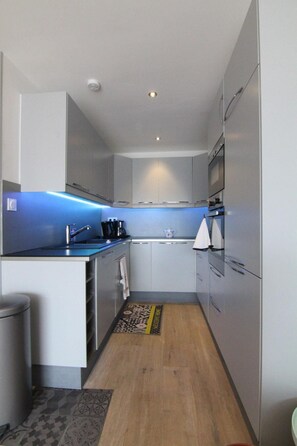 A compact kitchen with modern appliances, a sink, and a small countertop area. - 100m from resort center, 1st floor, balcony, tv, 41m², Alpe d'Huez (L'Alpe d'Huez)