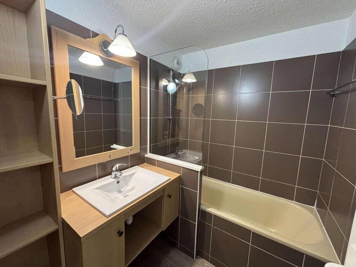 A bathroom with a white sink, a mirror, a shower, and a bathtub.