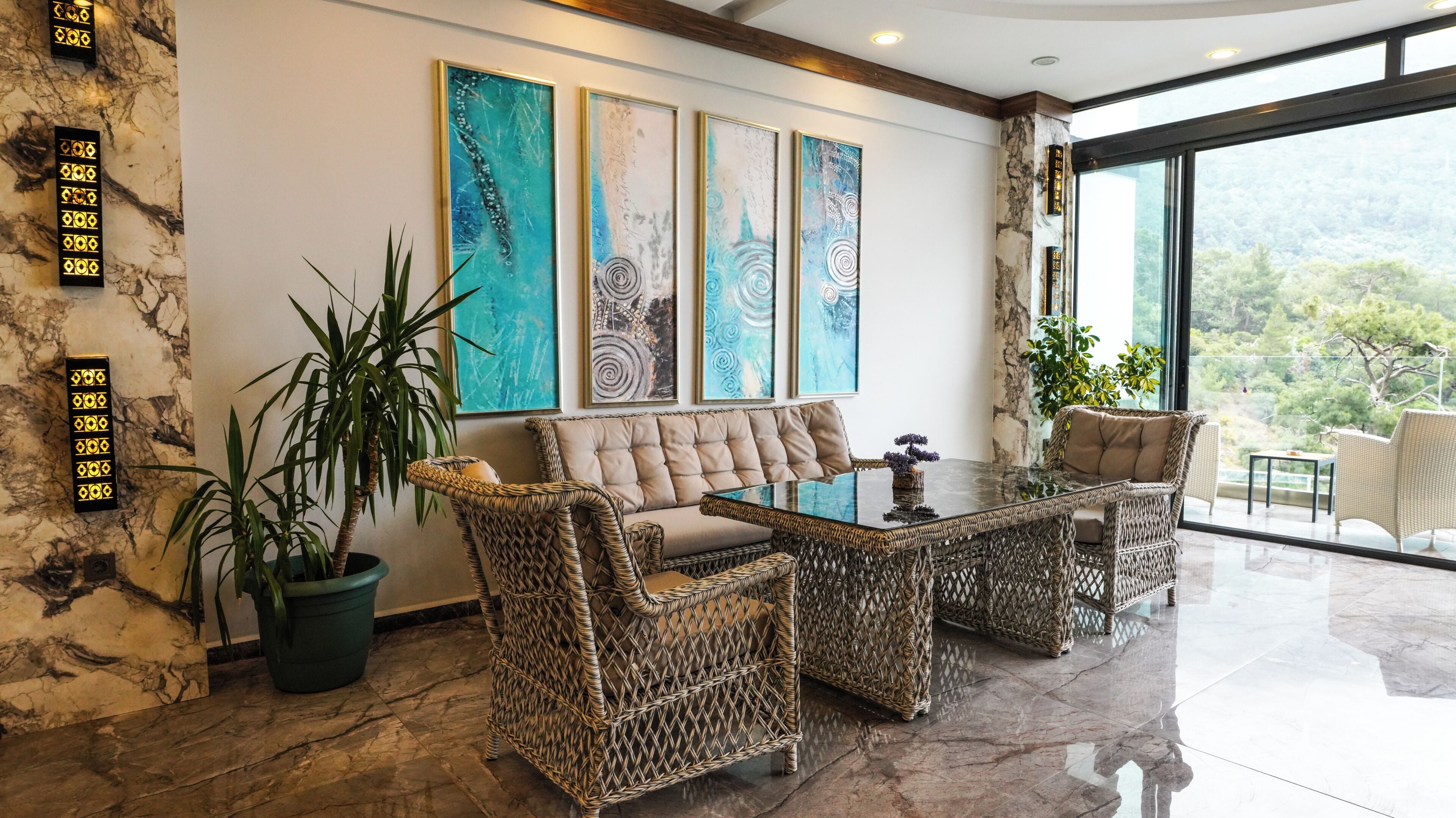 A modern interior with a sofa, two wicker chairs, a glass coffee table, and abstract art on the wall.