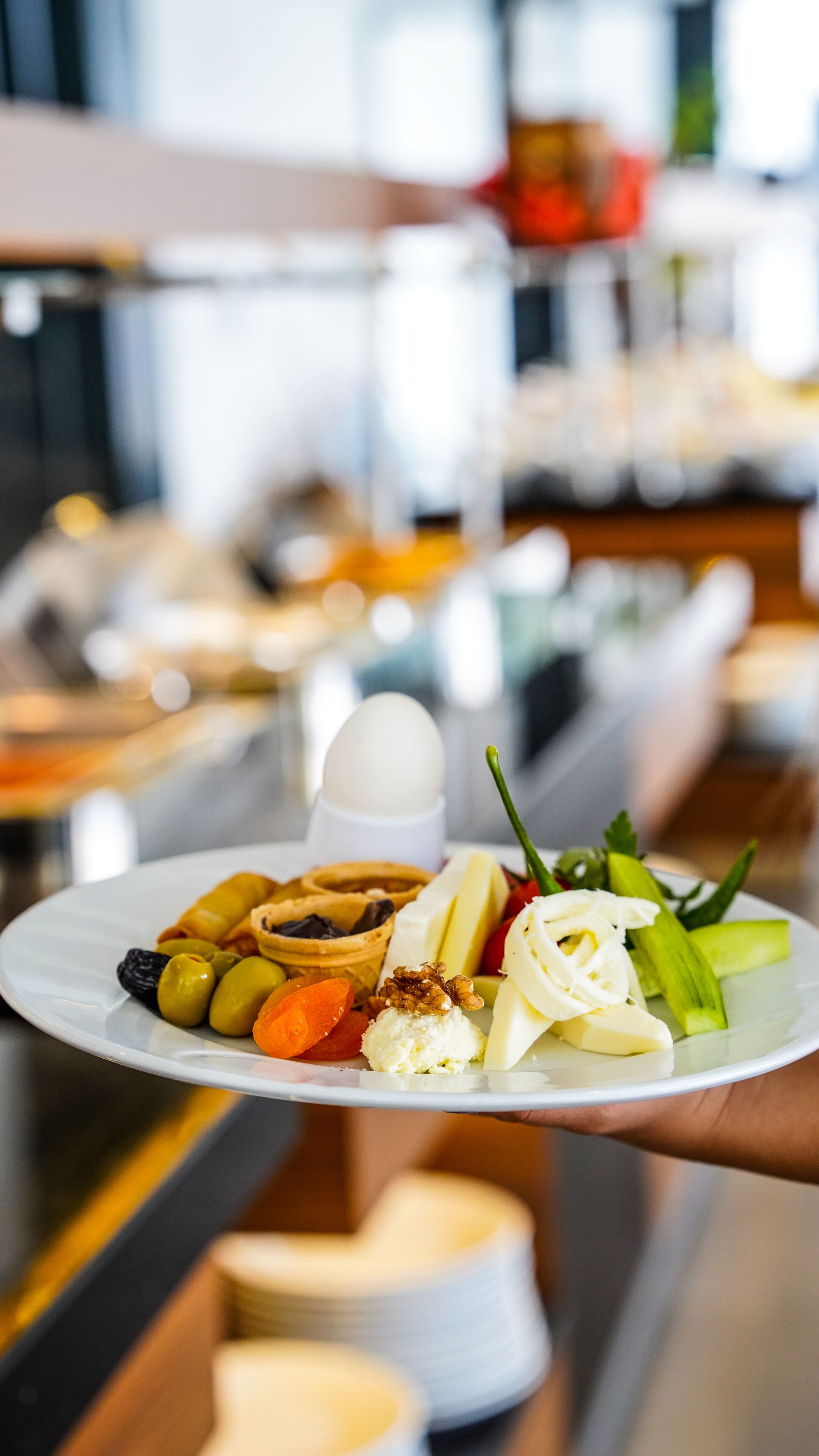 A plate of assorted food items including cheese, nuts, and vegetables.