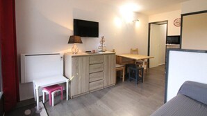 A compact room with a kitchenette, a dining area, and a small seating space. - 100m from ski slopes, 3rd floor, balcony, tv, ski locker, 24m², Alpe d'Huez (L'Alpe d'Huez)