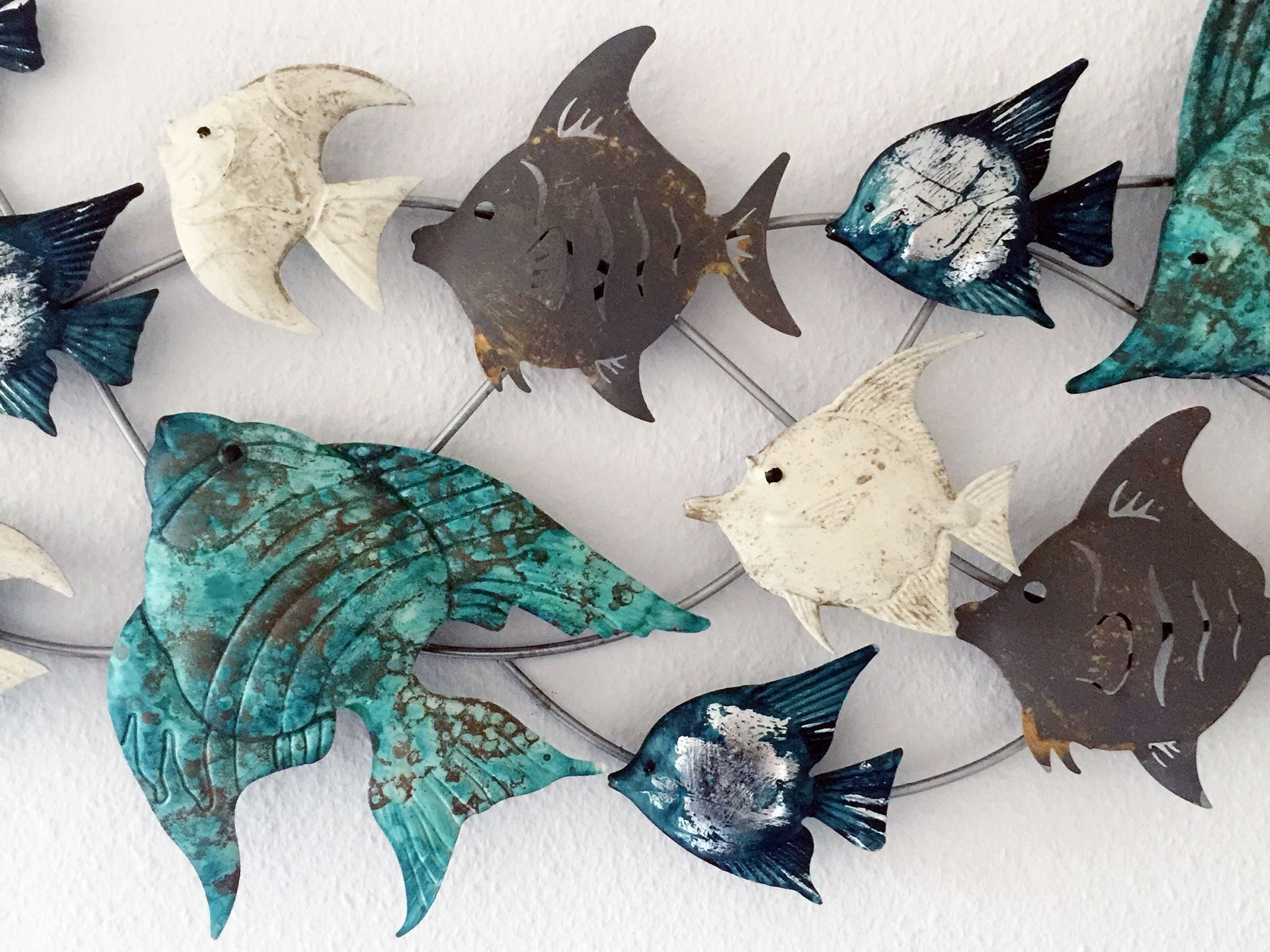 A wall with a decorative fish-themed arrangement.
