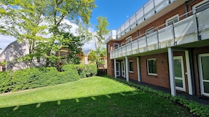 A modern building with a brick facade, large windows, and a well-maintained lawn.