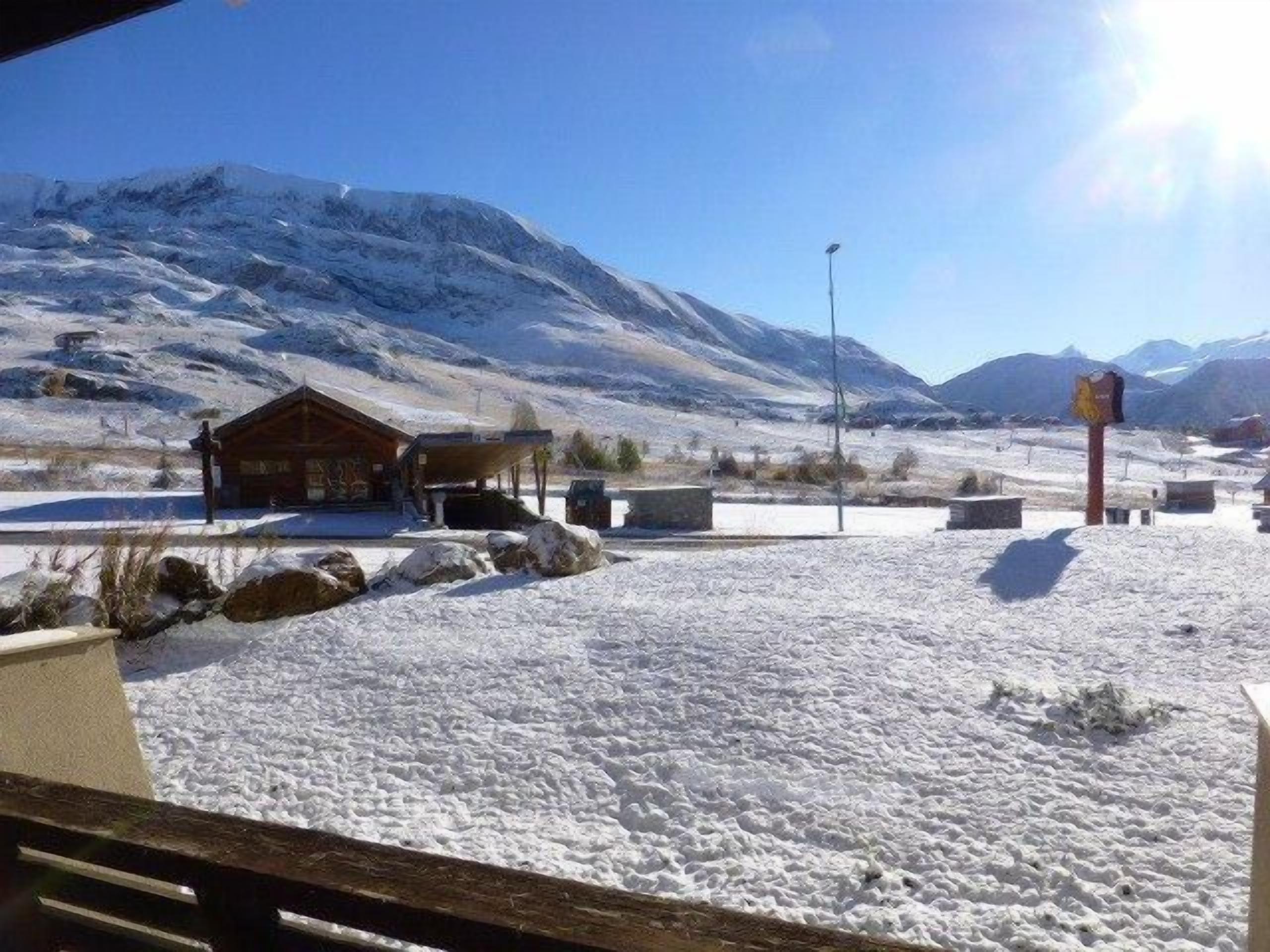 A snow-covered landscape with a wooden cabin and a clear sky.