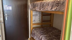 A compact room with a bunk bed, a wooden door, and a small window. - 2nd floor, tv, ski locker, 25m², Alpe d'Huez (L'Alpe d'Huez)