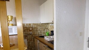 A compact kitchen with white cabinets, a tiled backsplash, and a wooden countertop. - 2nd floor, tv, ski locker, 25m², Alpe d'Huez (L'Alpe d'Huez)