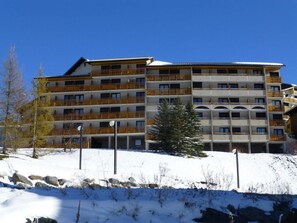 Experience the hotel's elegant facade, featuring balconies on each floor and a mix of rectangular and arched windows.