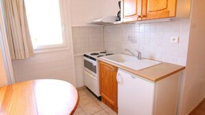 Una cocina funcional con estufa, lavabo y armarios de madera.
