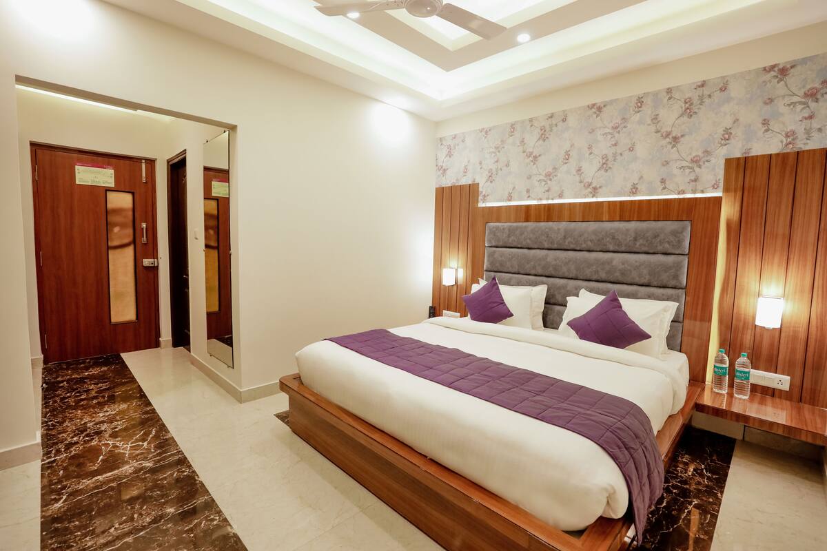 Ein modernes Hotelzimmer mit einem großen Bett, einem Holzkopfende und einem Marmorboden.