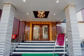 A hotel entrance with a checkered pattern, a chandelier, and a sign welcoming guests to the resort. - Regenta Resort Madhuganga Ukhimath (Ukhimath)