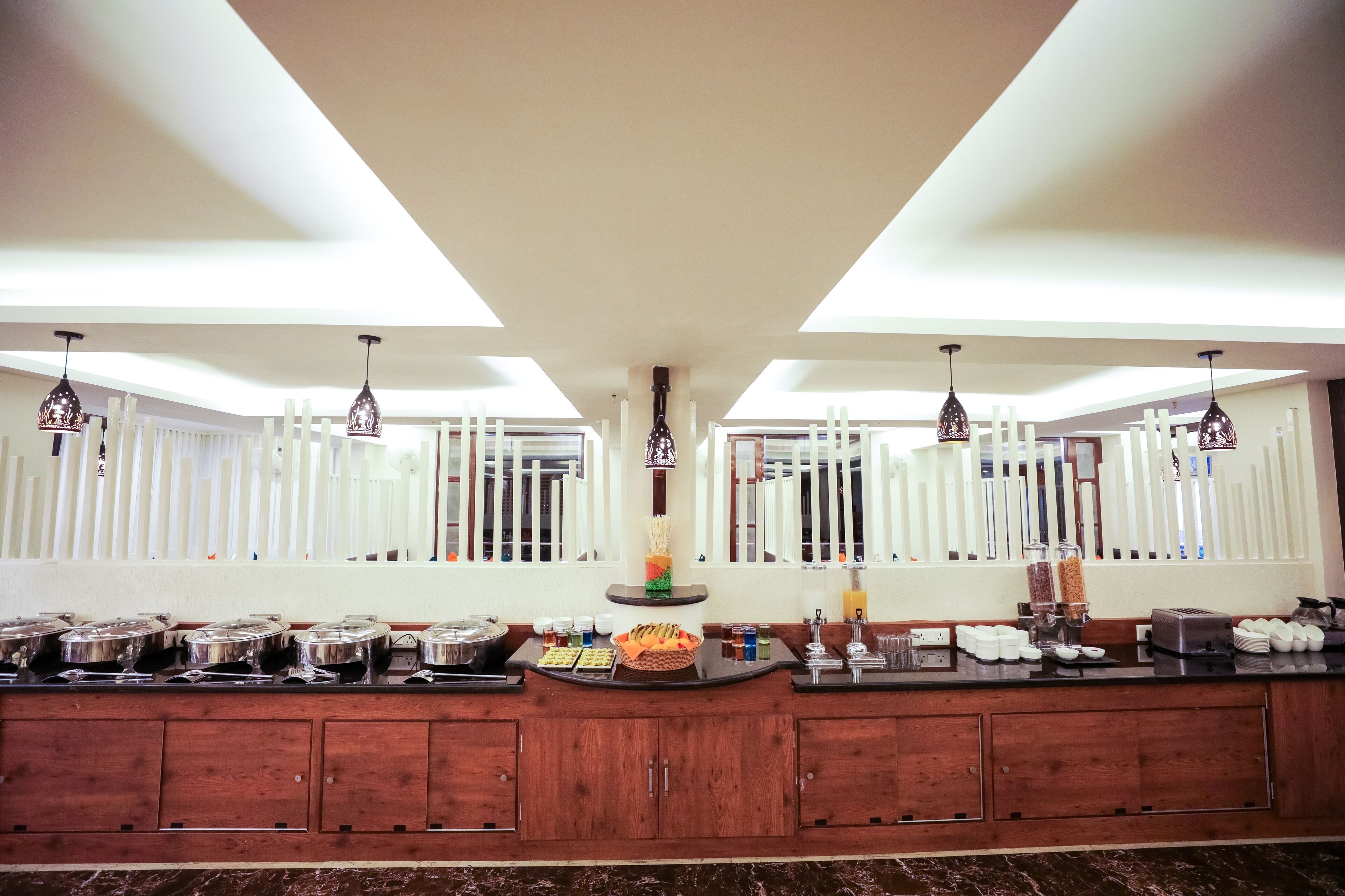A buffet setup with various food items and serving utensils.