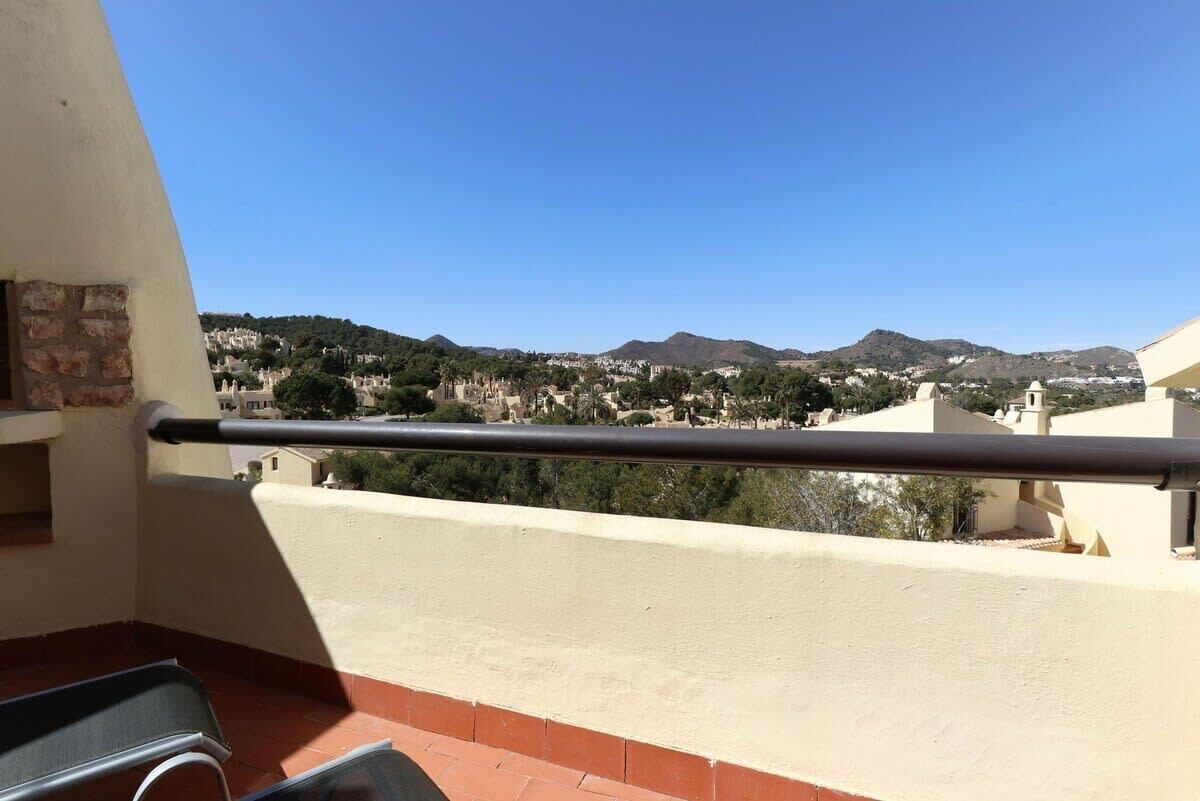 Un balcón con vista a un pueblo y montañas.