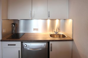 A compact kitchen with a dishwasher, a sink, and a stove.
