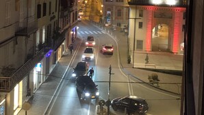 A nighttime street view with buildings, a clock tower, and a red-lit archway. - Center Salo’, near to Duomo,  to Vittoriale D’Annunzio (Salò)