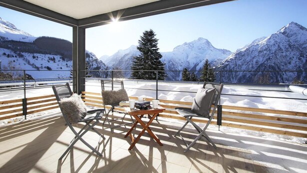 Ein moderner Balkon mit Blick auf schneebedeckte Berge.