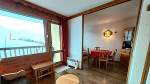 Una habitación acogedora con un banco de madera, una mesa redonda y un comedor con sillas y una mesa.