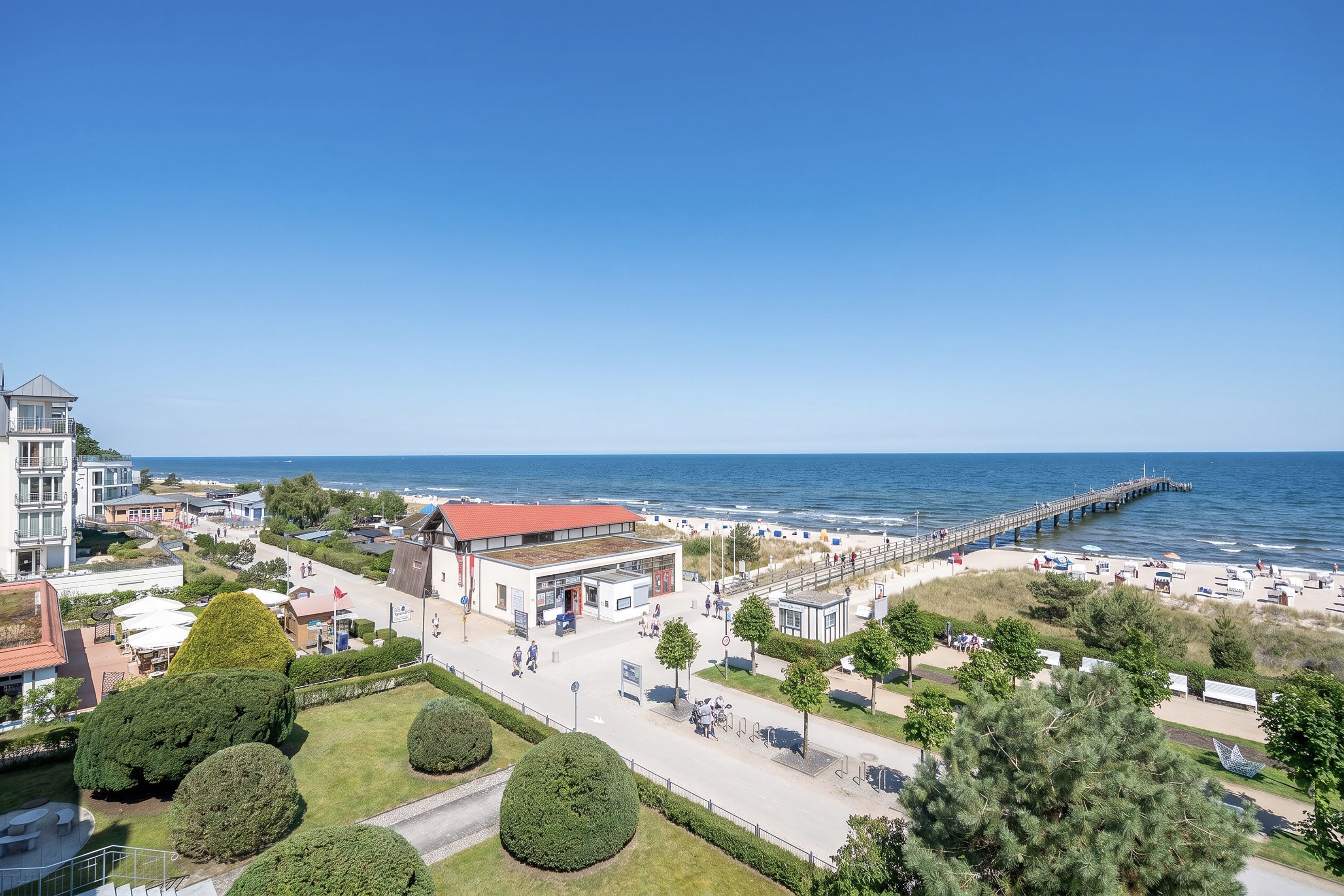 Un hôtel situé sur la côte, avec vue sur la plage, une jetée et un parking.