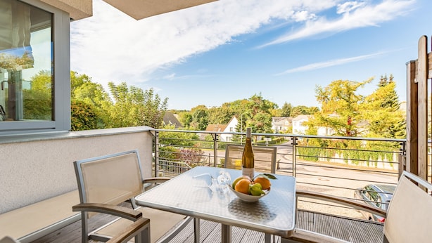 A balcony with a table, chairs, and a bowl of fruit and a bottle. - Quartier II, App. 2.2 (Heringsdorf)