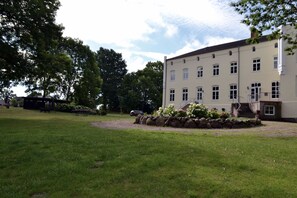 A building with a symmetrical facade, multiple windows, and a central staircase leading to the entrance.