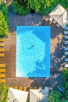 Una piscina al aire libre de temporada, sombrillas, tumbonas
