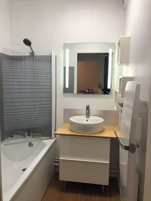 Bathtub, hair dryer, towels, toilet paper