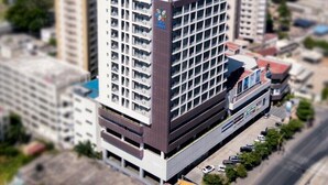 Un hôtel à plusieurs étages, avec un toit bleu et une enseigne indiquant « Dura Suites ».