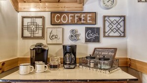 Una estación de café con cafetera, tazas y un cartel que dice "COFFEE".