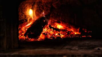 Primer plano de un fuego ardiendo en una chimenea, mostrando troncos y brasas incandescentes.
