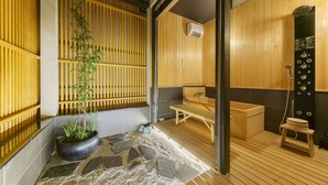 A traditional Japanese-style room with tatami flooring, a shoji screen, a stone pathway, and a wooden bench.