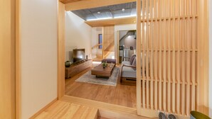 A modern living room with a TV, sofa, and wooden flooring.