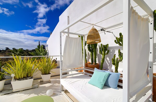 A balcony with a white bed, potted plants, and cacti. - Villa Rafa with Private Pool, Garden, Wi-Fi & A/C (Albufeira)