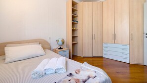 Une chambre à coucher avec un lit, une table de chevet, un globe terrestre et une armoire.