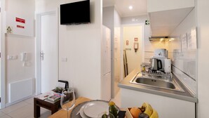 Een moderne keuken met een ingebouwde magnetron, koffiezetapparaat en een spoelbak.