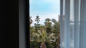 A window view of a landscaped area with various trees and shrubs.