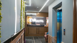 A reception area with a reception desk, a reception sign, and an elevator.