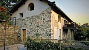 A stone house with a balcony and a wooden fence.