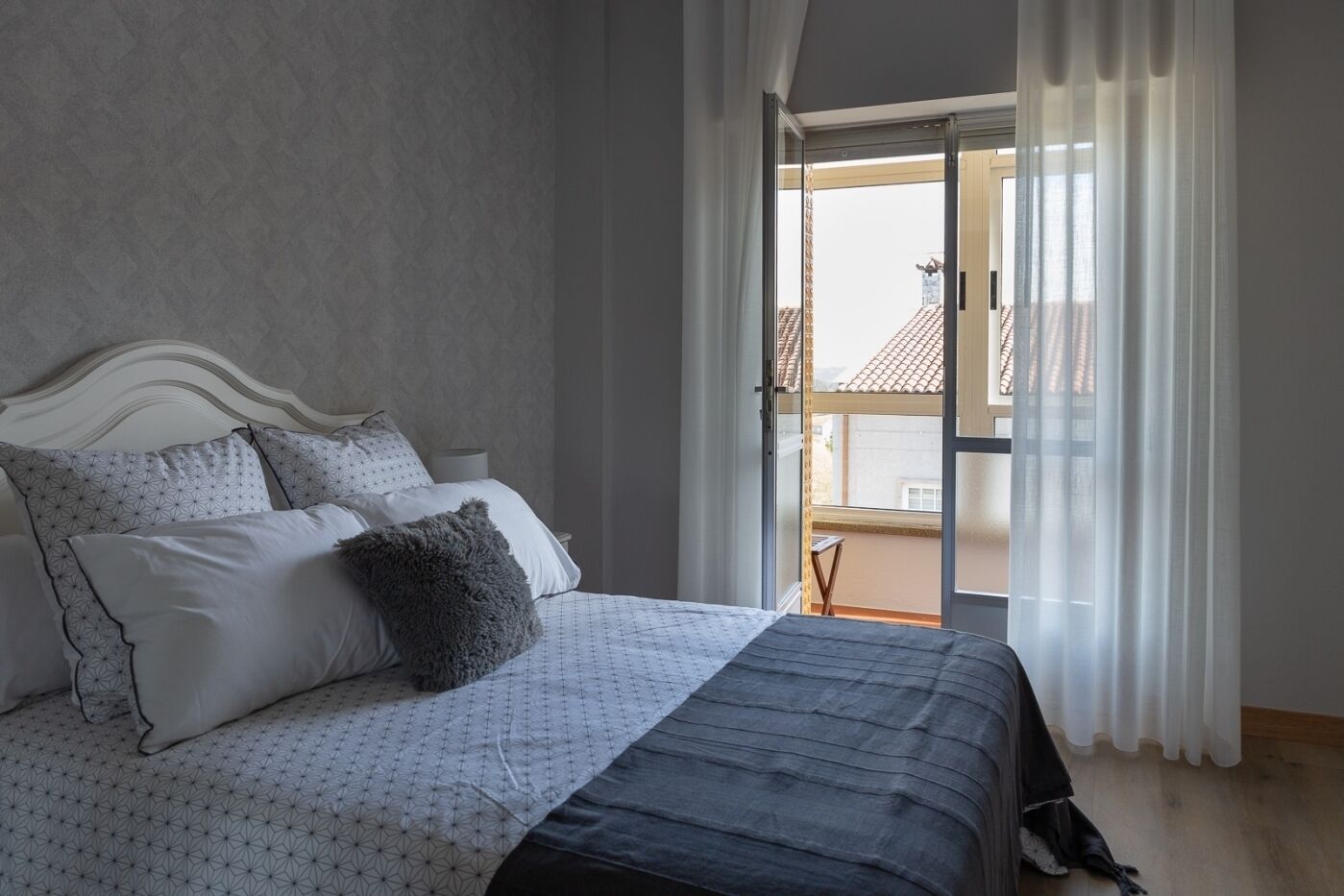 Una camera da letto con un letto, una finestra e vista sugli edifici.
