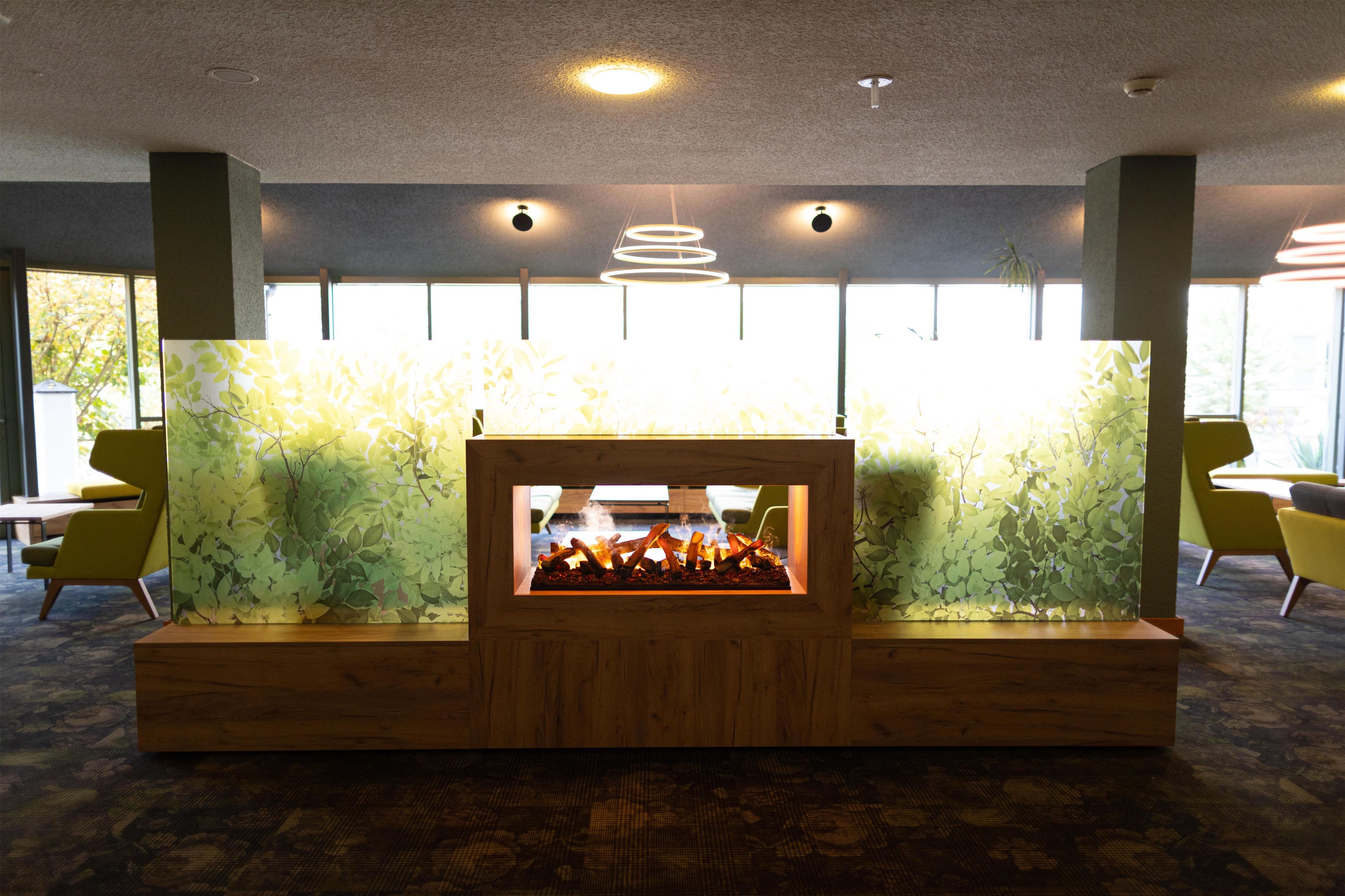 A reception area with a fireplace, seating, and a view of the outdoors.